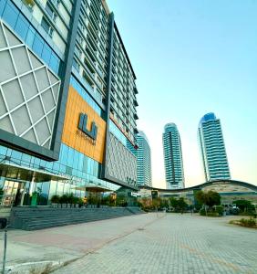 a large building in a city with tall buildings at 1BR Luxury Apartments With Balcony & Mountains View In Elysium Tower OPP Centaurus Mall Islamabad in Islamabad