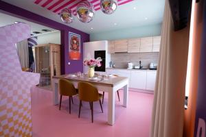 a kitchen with a white table and two chairs at Capsule Retro Balnéo - Sauna - Billard -Switch 2 in Limelette