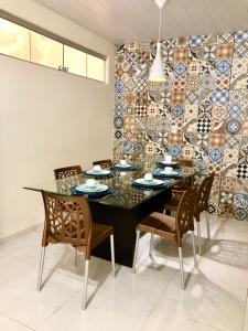 a dining room with a table and chairs and a mosaic wall at Casa três quartos em condomínio in Garanhuns +8 photos