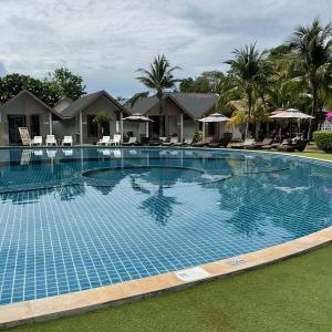 a large swimming pool in a resort with palm trees at Phi Phi Andaman Legacy Resort in Phi Phi Islands