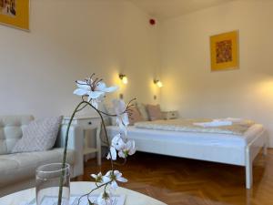 a living room with a bed and a table with flowers at Szilva Ház in Szilvásvárad +61 photos
