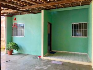 a room with a green wall and a door at Casa três quartos em condomínio in Garanhuns