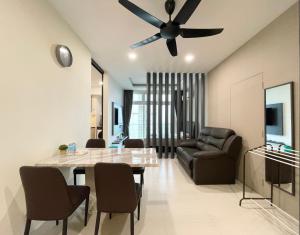 a living room with a table and a ceiling fan at Blue Cove Riverine Diamond Kuching in Kuching