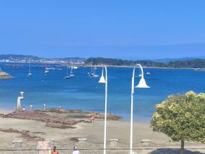 a street light on a beach with boats in the water at Pensión Chiquilla in O Grove