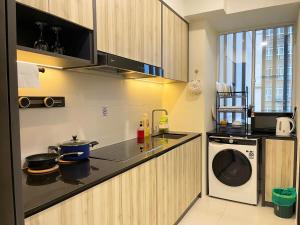 a kitchen with a sink and a washing machine at Blue Cove Riverine Diamond Kuching in Kuching