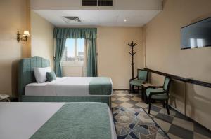 ein Hotelzimmer mit zwei Betten und einem Fernseher in der Unterkunft Holidays Express Hotel Cairo in Kairo + 51 Fotos