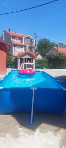 a large blue pool with a red float in front of a house at Honey House Martinovic in Cetinje