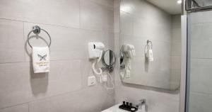 a bathroom with a shower and a sink and a phone at Shitaye Suite Hotel in Addis Ababa +69 photos