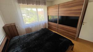 a bedroom with a bed and a large wooden cabinet at Apartment Kristian in Selnica ob Dravi