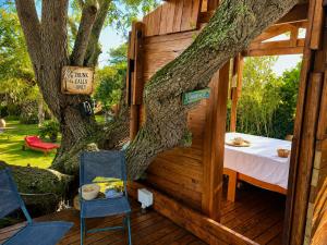 a treehouse with a bed and chairs on a deck at Goblin's Creek in St. Helena Bay