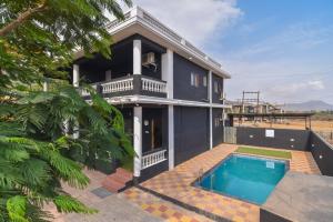 a house with a swimming pool in front of it at ll EMPYREAN STAYS ll BLACK PANTHER VILLA ll in Lonavala