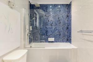 a bathroom with a white tub and a blue wall at Azure Apartment in Senglea +93 photos