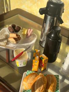 a table with a tray of bread and a plate of food at Pousada Encanto De Itanhaém in Itanhaém