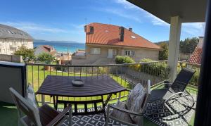 a patio with a table and chairs on a balcony at Canelas 22 in Sanxenxo