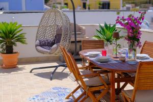 a patio with a table and chairs and a swing at La Casa di Barbara in Ponza