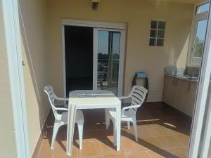 a white table and chairs in a kitchen at La pineda in Les tres Cales +9 photos