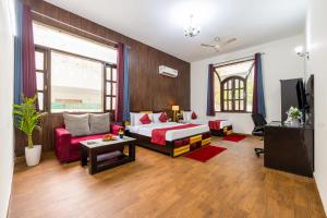 a hotel room with a bed and a couch at Nook Inn & Suites - 2 Min Walk From MG ROAD METRO in Gurgaon