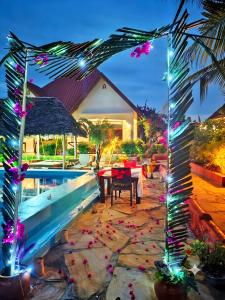 a resort with a pool and a table with lights at Mimi na wewe villa in Nungwi +154 photos