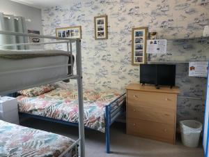 a bedroom with two bunk beds and a television at Mudeford Swans in Christchurch