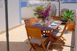 a wooden table with chairs and flowers on it at La Casa di Barbara in Ponza +11 photos