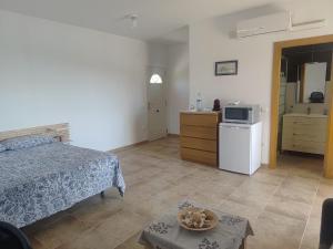 a bedroom with a bed and a kitchen with a microwave at La pineda in Les tres Cales