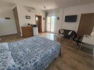 a bedroom with a bed and a couch and a television at La pineda in Les tres Cales