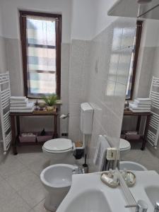 a bathroom with a toilet and a sink and a mirror at Casa Maya Langhe e Roero in Pocapaglia +6 photos