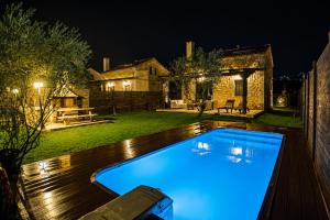 a swimming pool in a backyard at night at 5 Stars Villas in Svoronata