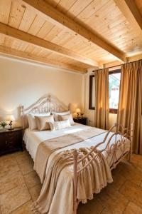 a bedroom with a large bed with a wooden ceiling at 5 Stars Villas in Svoronata