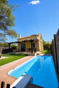 a villa with a swimming pool in front of a house at 5 Stars Villas in Svoronata +5 photos