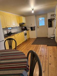 a kitchen with yellow cabinets and a table and chairs at Storgatan 42 in Högsby
