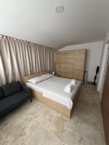 a bedroom with a large bed and a couch at Apartments La Natalli in Baška
