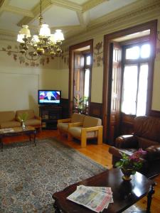 sala de estar con sofá y TV en Guesthouse Lusa Atenas en Coímbra