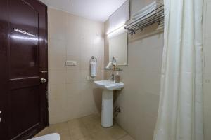 a bathroom with a sink and a toilet and a shower at Nook Inn & Suites - 2 Min Walk From MG ROAD METRO in Gurgaon +34 photos
