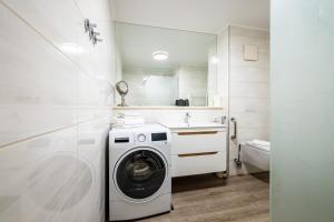 a white laundry room with a washer and dryer at Exklusive Ferienwohnung am Südstrand mit Meerblick & Balkon Wohnung 10 in Wilhelmshaven