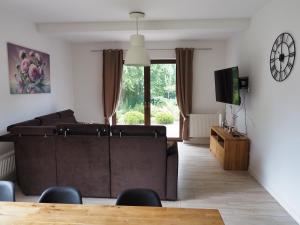 a living room with a couch and a tv at Apartamenty bez barier in Rydzewo +33 photos
