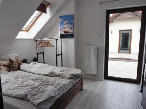 a bedroom with a bed and a large window at Apartamenty bez barier in Rydzewo