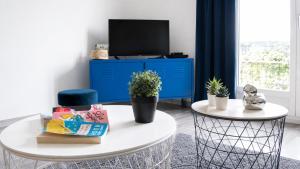 a living room with a white table and a blue cabinet at HAPPY HOME COLMAR with PRIVATE PARKING in Colmar