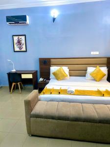 a bedroom with a bed and a couch and a desk at Bridgewaters Hotel in Abuja