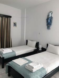 a room with two beds with towels on them at Atlantis Place Milos in Adamantas
