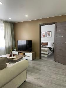 ein Wohnzimmer mit Sofa und Fernseher in der Unterkunft ZimApartment in Jõhvi