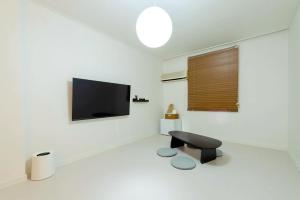 a living room with a tv and a black stool at 브릭스테이 brikstay in Gyeongju