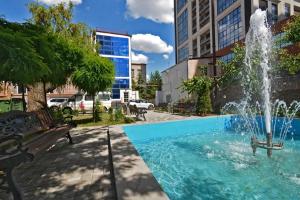 a fountain in the middle of a park with a bench at Seva Apart-Hotel in Yerevan
