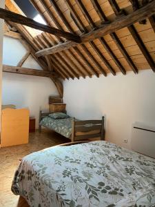 a bedroom with a bed in a room with wooden ceilings at Le domaine de l'Ebenne in Englefontaine