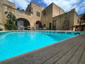 a pool in a building with blue water at A la maison B&B in Xagħra