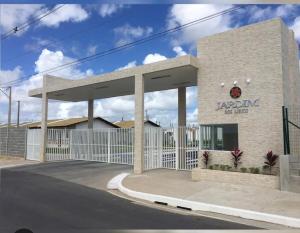 a building with a fence in front of a parking lot at Casa Maceió The perfect place in Maceió