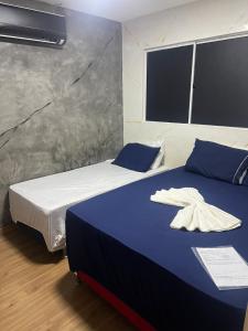 a bedroom with two beds with blue and white sheets at Casa Maceió The perfect place in Maceió