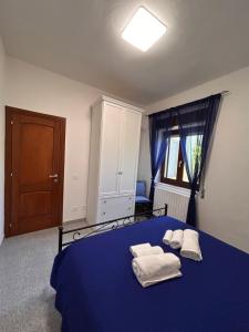 a bedroom with a blue bed with towels on it at Màrila in Aggius
