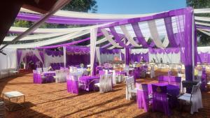 a marquee with purple and white tables and chairs at Hotel Sartaj in Dera Bassi