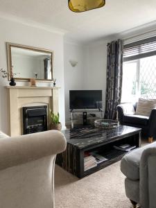 a living room with a fireplace and a table at 3-Bed Retreat Perfect Contractors & Leisure Stays Onsite Parking in Messingham